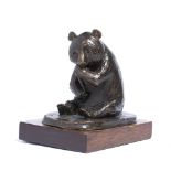 Bronze model of a Panda squatting on its haunches eating bamboo, on a wooden plinth, indistinctly