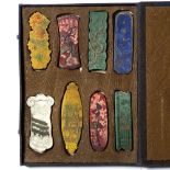 Cased set of eight ink stones Chinese in varying colours depicting houses, flowers and dragons the