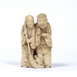 Carved ivory okimono Japanese, Meiji period in the form of two standing figures, one holding a
