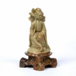 Soapstone figure of Guanyin Chinese seated with hands resting on her lap, on a rocky shaped base