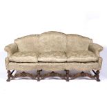 Walnut Carolean style sofa with carved and shaped frame and with loose cushions, 208cm across,