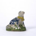 Delftware model of a dog 18th Century, blue and manganese sponged decoration and green mound base,