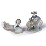 Lladro porcelain model of a girl carrying a wheelbarrow with puppies, 23cm and a Nao porcelain model