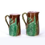 In the manner of George Jones Two graduated majolica jugs, 19th Century with floral decoration,