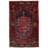 Red ground rug with central medallion and foliate border, 234cm x 170cm approx
