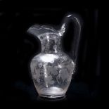 Etched glass jug decorated to the body with flowers and grapes, with stylised rim, 25.5cm high