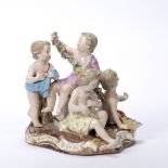 Porcelain putti group Meissen, late 19th Century, the figures holding garlands and posies of