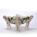 Porcelain oval basket Sitzendorf, supported by four putti, 33cm across, 15cm high