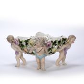 Porcelain oval basket Sitzendorf, supported by four putti, 33cm across, 15cm high