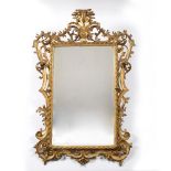 Carved gilt wood wall mirror circa 1830, with foliate scroll border, the top with acanthus leaf