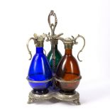 Set of three coloured glass claret jugs with silver plated mounts on a silver plated decanter