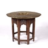 Brass and folding occasional table Indian with carved teak base, 78cm across, 65cm high