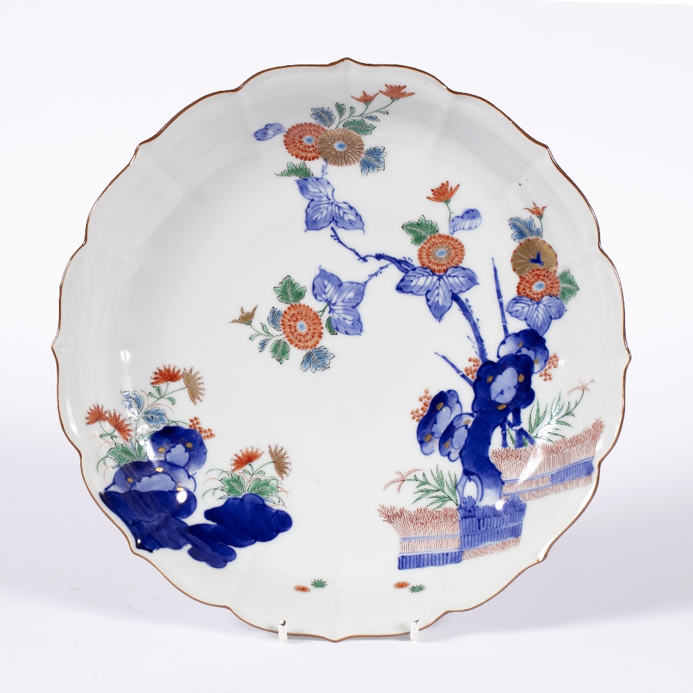 Kakiemon polychrome dish Japanese, 19th Century painted with rock work, flowers and a fence within
