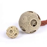 Canton carved ivory puzzle ball Chinese, 19th Century 10cm across and a smaller puzzle ball, 5.5cm