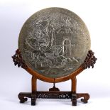Bronze circular plaque Chinese, circa 1900 depicting warrior figures at the entrance of a fort, on a