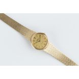 A LADY'S 9CT GOLD BRACELET WATCH BY LONGINES, the circular signed gilt dial with baton markers, to a