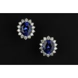 A PAIR OF TANZANITE AND DIAMOND CLUSTER EAR STUDS, each oval mixed-cut tanzanite claw set within a