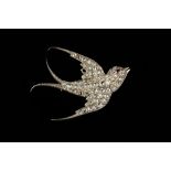 A DIAMOND SET SWALLOW BROOCH, naturalistically modelled as a swallow in flight, with rose-cut