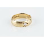 A DIAMOND SET BAND RING, the 18ct gold band centred with a round brilliant-cut diamond in star-