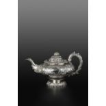 A GEORGE IV SILVER TEAPOT, of compressed globular form, embossed and chased with flowering