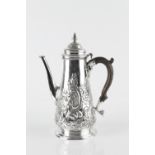 A MID 18TH CENTURY SILVER COFFEE POT, the tapering body and hinged cover later repoussé decorated