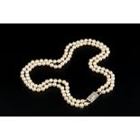 A CULTURED PEARL NECKLACE WITH DIAMOND SET CLASP, comprising two strands of uniform cultured pearls,