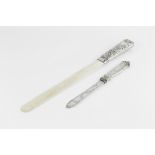 A LATE VICTORIAN SILVER HANDLED IVORY PAGE TURNER, the handle embossed with scrolling foliage,
