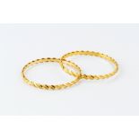 TWO YELLOW PRECIOUS METAL BANGLES, each of continuous part-textured twist design, stamped 'P.J 22C',