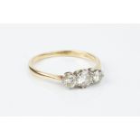 A DIAMOND THREE STONE RING, the graduated round brilliant-cut diamonds in claw setting, two colour