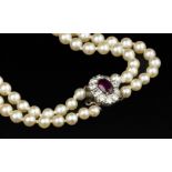 A CULTURED PEARL NECKLACE WITH RUBY AND DIAMOND CLASP, comprising two strands of graduated