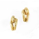 A PAIR OF EAR CLIPS BY CARTIER, of textured knot-shaped half hoop design, on post and hinged clip