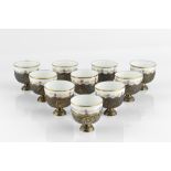 A SET OF TWELVE EARLY 20TH CENTURY TURKISH SILVER GILT CUPS, embossed with castles and stylised