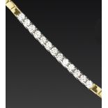 A DIAMOND LINE BRACELET, of segmented two colour design, centred with a line of uniform round