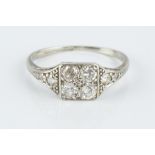 A DIAMOND PANEL RING, the square millegrained panel of four round brilliant-cut diamonds, between