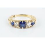 A SAPPHIRE AND DIAMOND FIVE STONE RING, the scroll pierced hoop alternately set with graduated