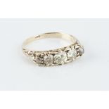 A DIAMOND FIVE STONE RING, the graduated old-cut diamonds to a scroll decorated hoop, yellow