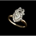 A DIAMOND PANEL RING, modelled as a heart-shaped cluster surmounted by a ribbon bow, the central