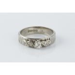 A DIAMOND SET BAND RING, the bark textured band applied with a spray of round brilliant and single-