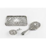 A LATE VICTORIAN SILVER RECTANGULAR DRESSING TABLE TRAY, repoussé decorated with birds, masks and