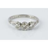 A DIAMOND THREE STONE RING, the graduated round brilliant-cut diamonds in claw setting, white