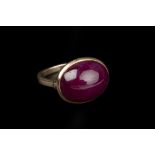 A RUBY SINGLE STONE RING, the oval cabochon ruby in collet setting, yellow precious metal mounted,