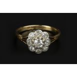 A DIAMOND CLUSTER RING, the flowerhead cluster of graduated old-cut diamonds in claw and collet