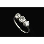 A DIAMOND THREE STONE RING, the graduated round brilliant-cut diamonds in claw setting, white