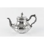 AN EARLY VICTORIAN SILVER TEAPOT, of lobed baluster form, chased and engraved with stylised foliage,