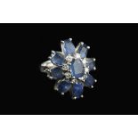 A SAPPHIRE AND DIAMOND CLUSTER RING, designed as a flowerhead cluster of oval mixed-cut sapphires