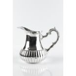 A PERUVIAN SILVER BALUSTER WATER JUG, with part lobed body, pierced foliate cast border, and