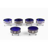 A SET OF FOUR GEORGE III SILVER OVAL SALTS, with pierced and engraved decoration, blue glass liners,