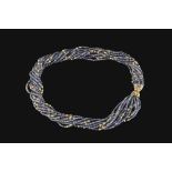 AN IOLITE BEAD TORSADE NECKLACE, comprising twelve entwined strands of iolite beads and yellow metal