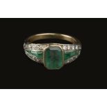 AN EMERALD AND DIAMOND PANEL RING, the principal rectangular step-cut emerald in collet setting,