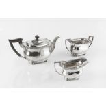 A SILVER THREE PIECE TEA SERVICE, with gadrooned and foliate scroll cast borders, on bun feet, the